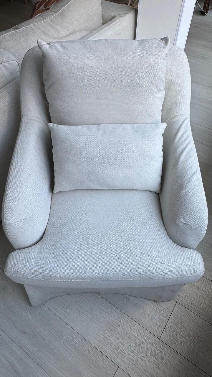 Sillón tapizado en tela color blanco roto con cojines