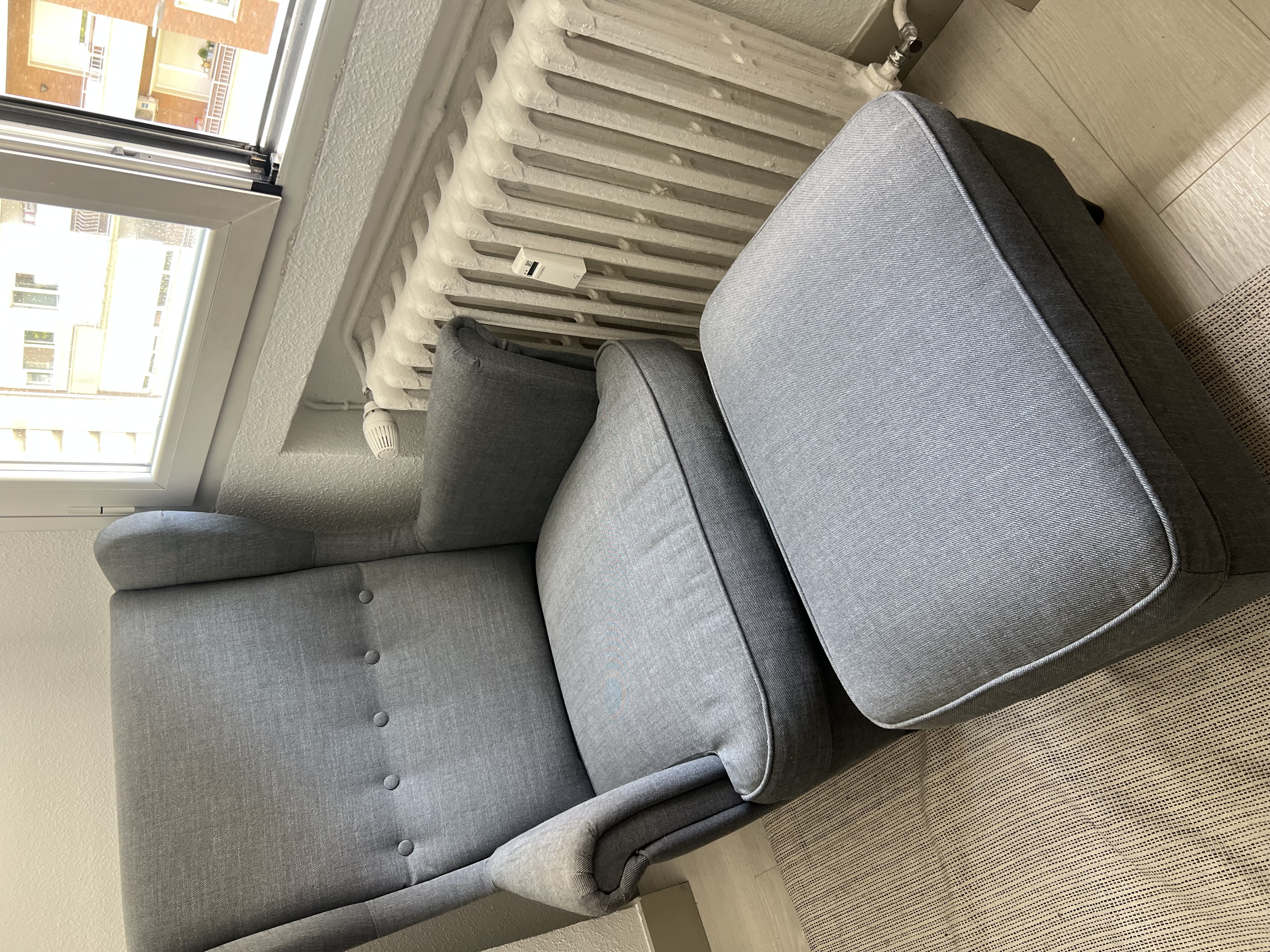 Sillón orejero gris con reposapiés a juego